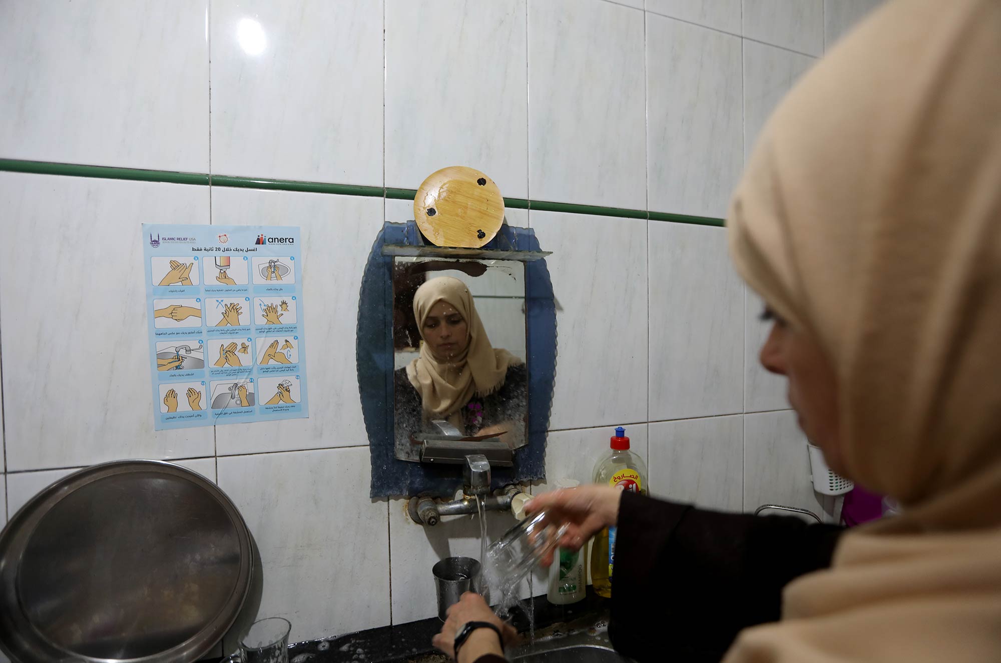 A woman in Jabalia refugee camp in Gaza washes her hands following Anera's hygiene guidelines.