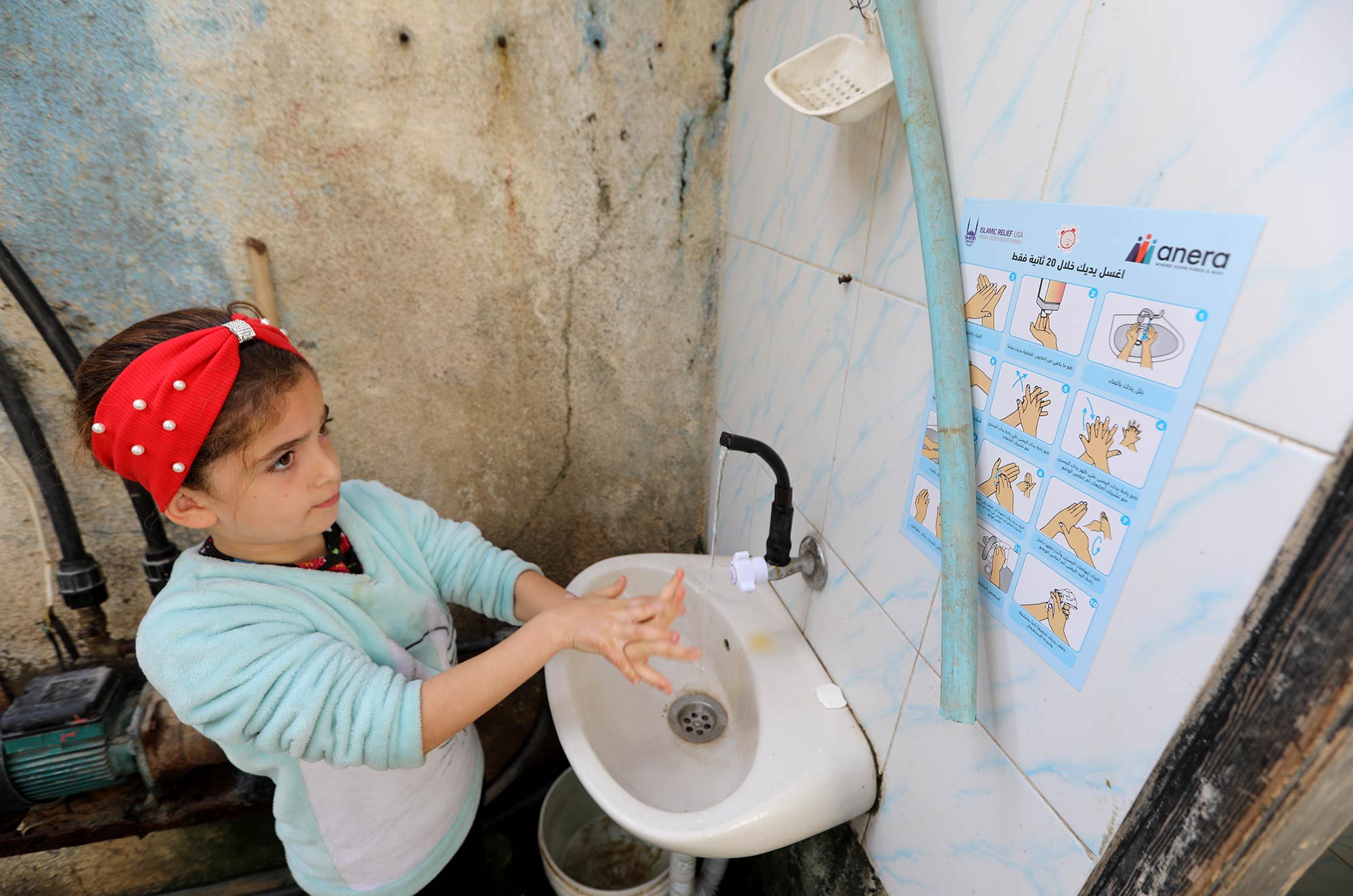 Iman’s niece washes her hands following Anera’s hygiene guidelines.