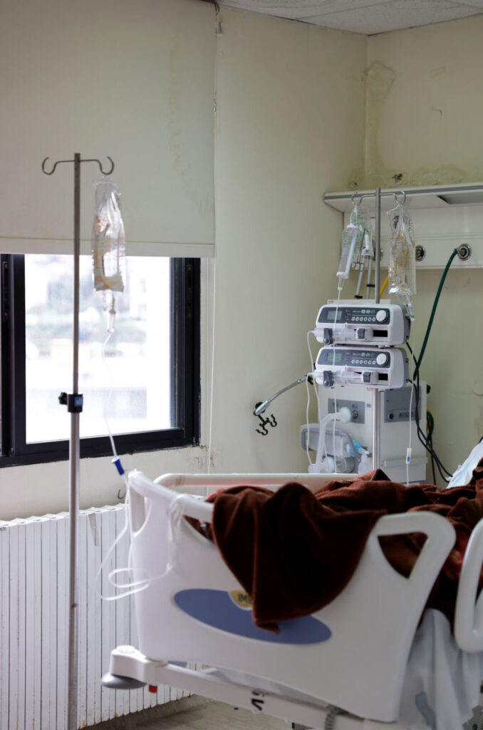 A hospital room with a bed with IV bag.
