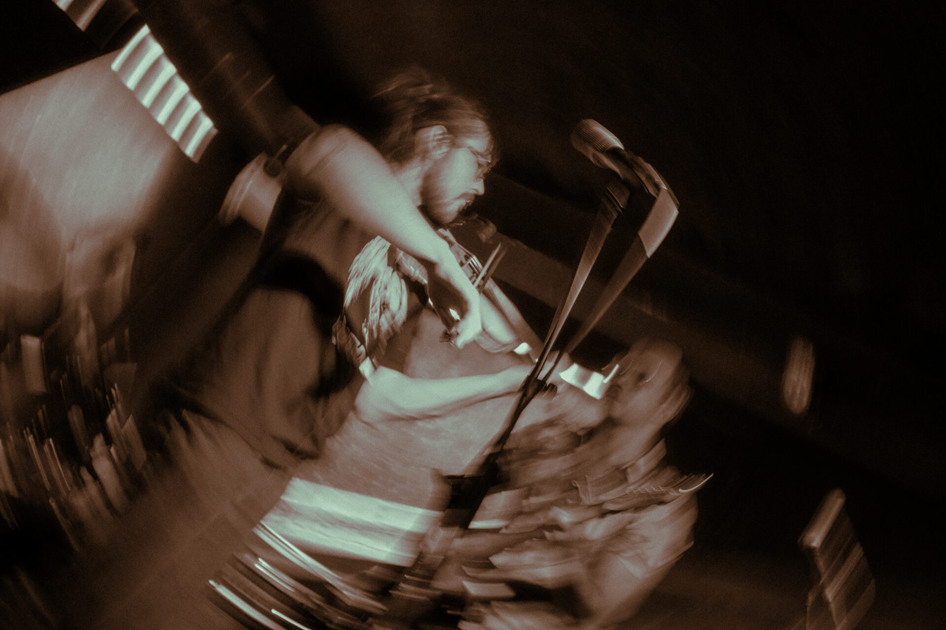 A blurry photograph of a man playing violinl.