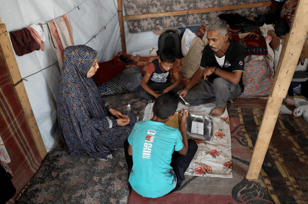 Majed and his family eat together in their tent.