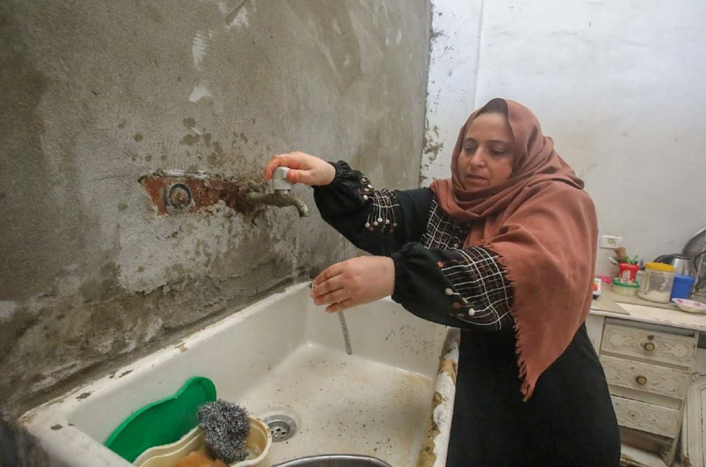 Um Naji runs a tap at her home.