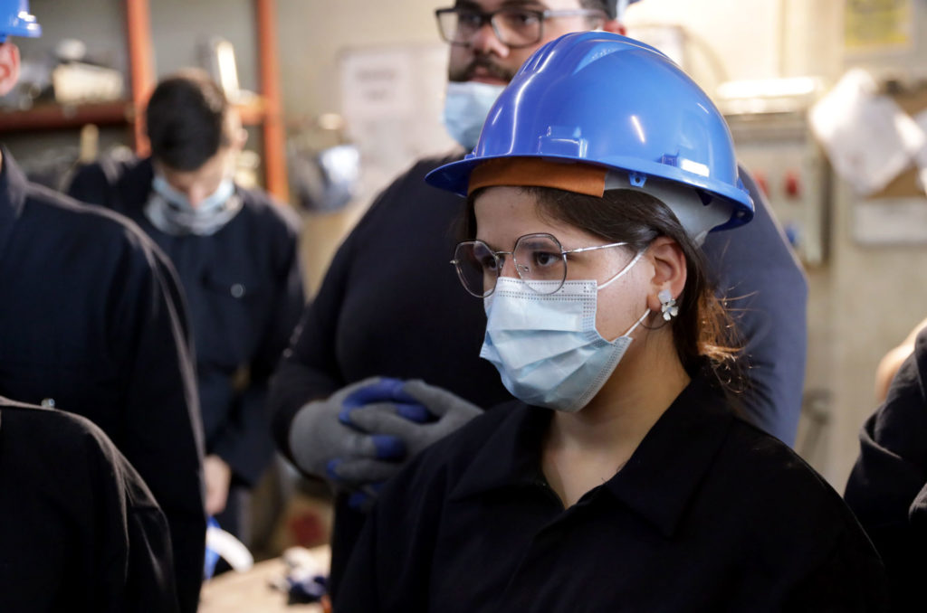 Hanan in hard hat and face mask at the training program.