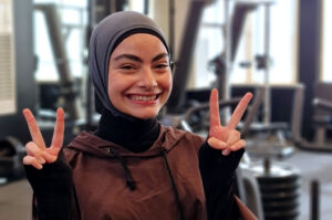 Rawan at her gym flashing V signs with her hands.