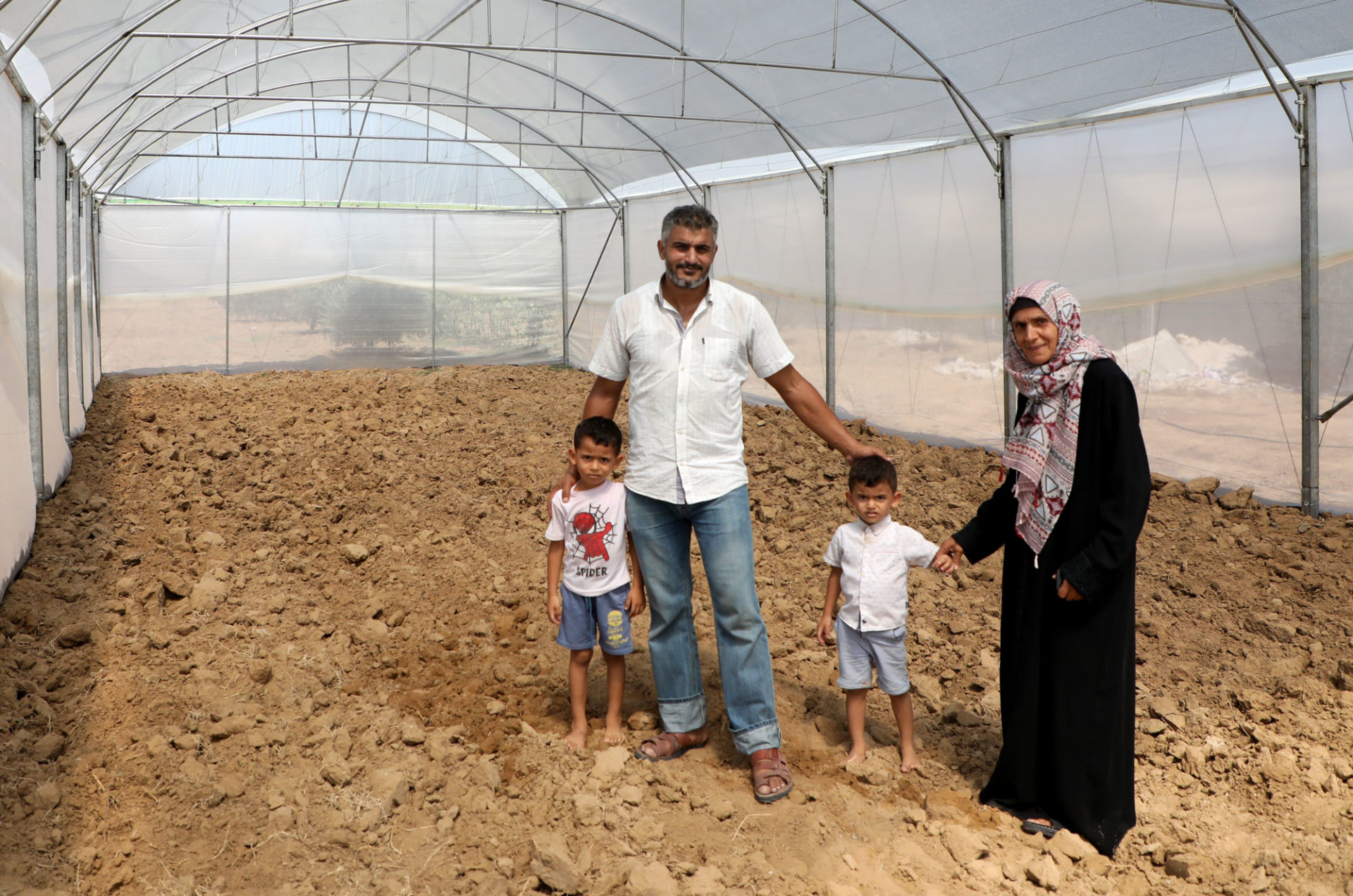 Habiba and her family in their greenhouse