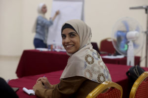 Maryam smiles at the camera while seated at the training.