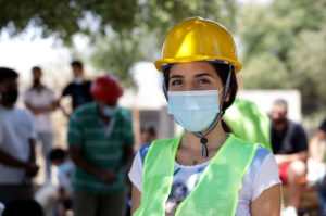 Lamis in hard hat and vest at a construction site.