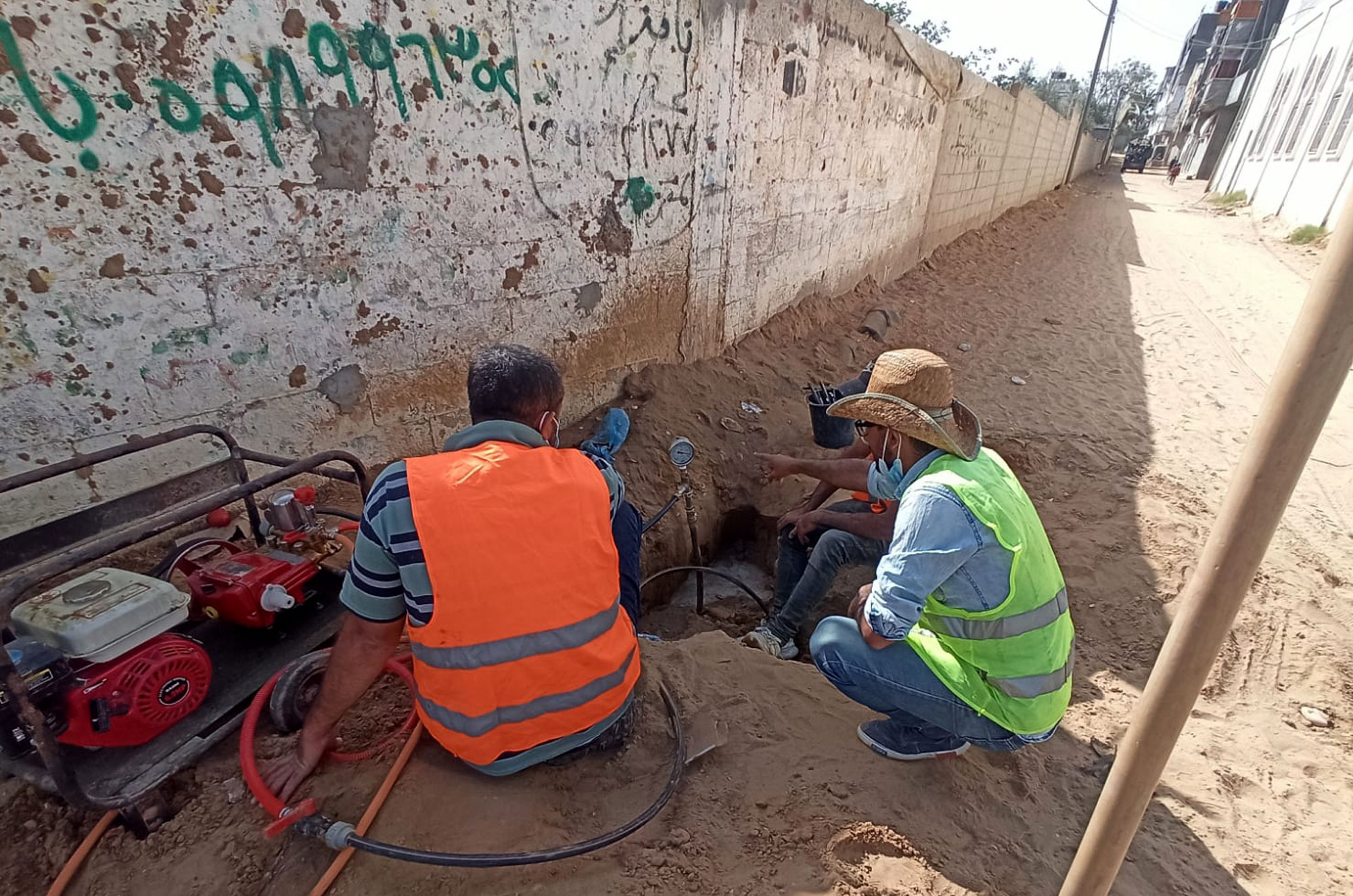 Checking a pressure gauge at a manhole along the water pipeline.