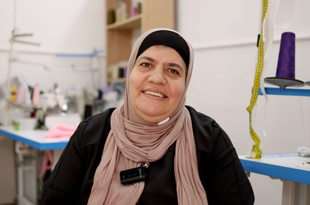 Nida in her work room, surrounded by the tools of her sewing trade.