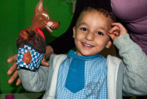 Preschool boy in Shatila Palestinian camp gets to play with hand puppets in refugee camp school supported by Anera.