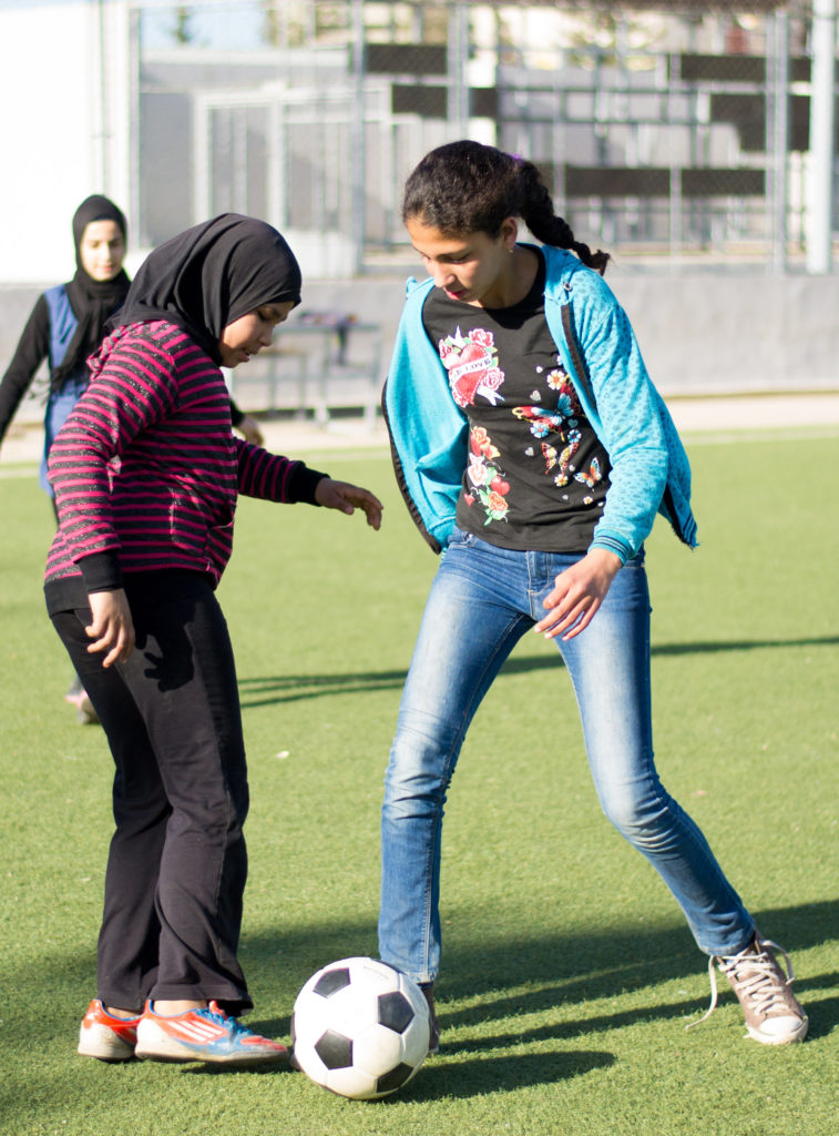Girls playing soccer on the soccer field Anera renovated in the Beddawi Palestinian refugee camp, part of the sports for peace and development program.