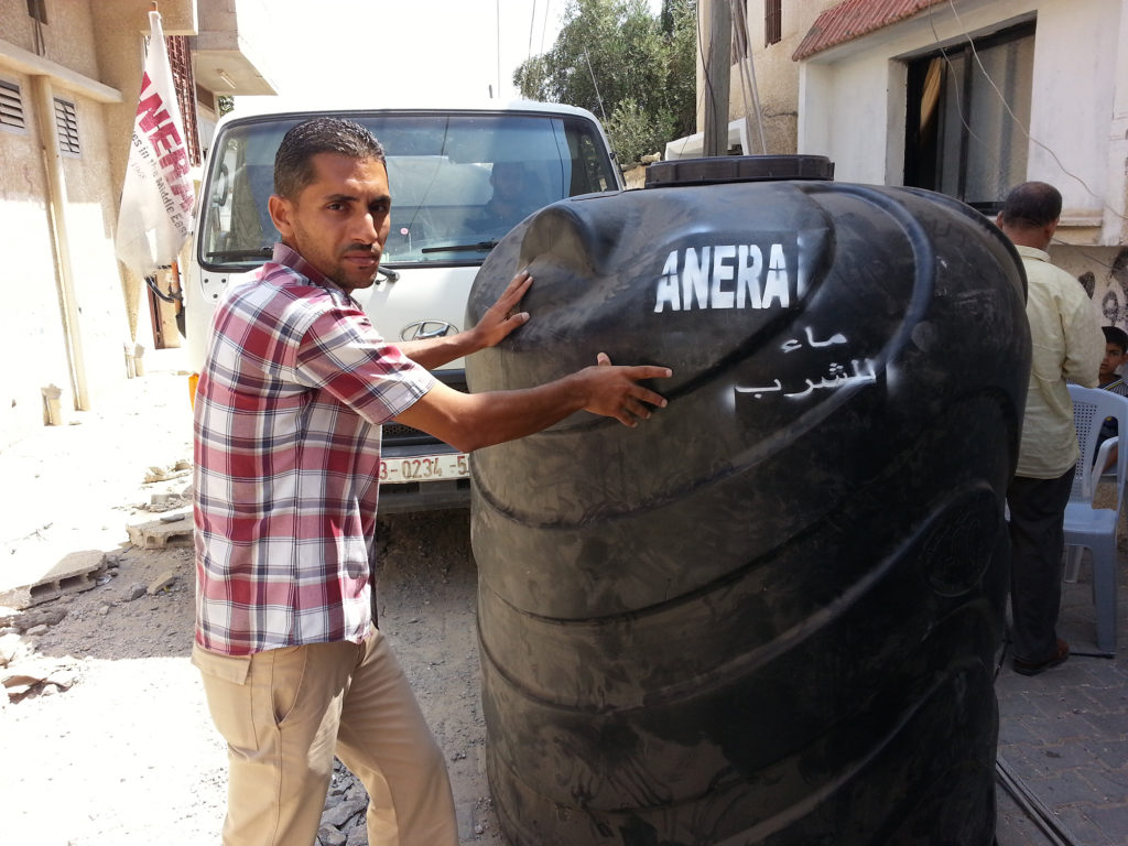 Ahmad Najjar with a large volume Anera water tank.