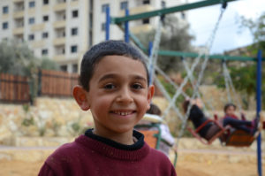 Young Palestinian boy enjoys the park and playground Anera built. in his West Bank community.