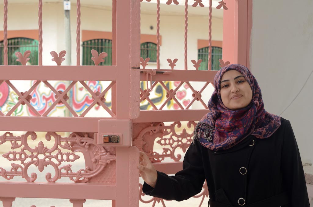 Preschool principal in Deir Al Balah, Gaza opens the gate to her Anera-renovated school.