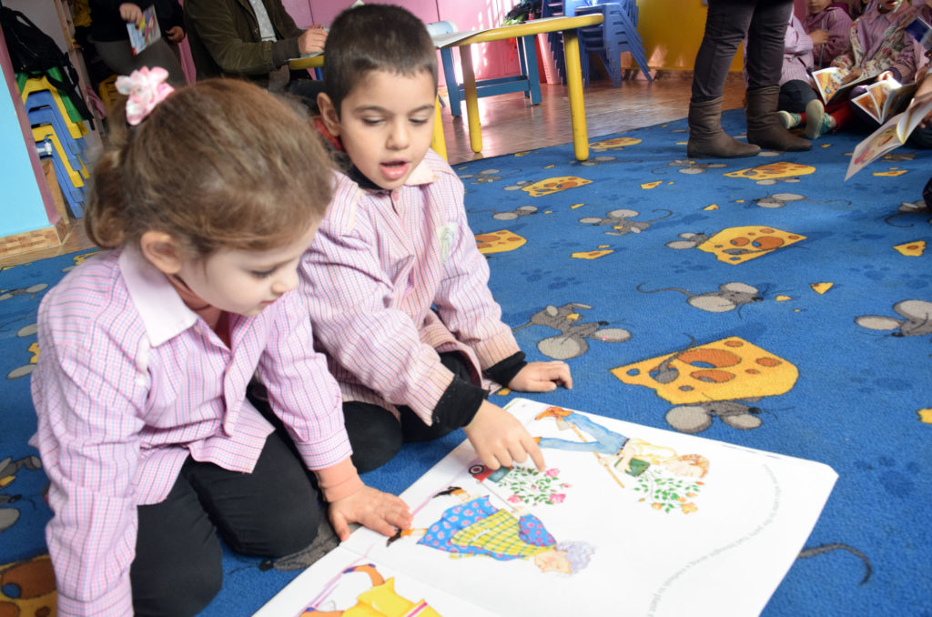 Hoda and her classmates in the Lebanon camp are engrossed in a new book.