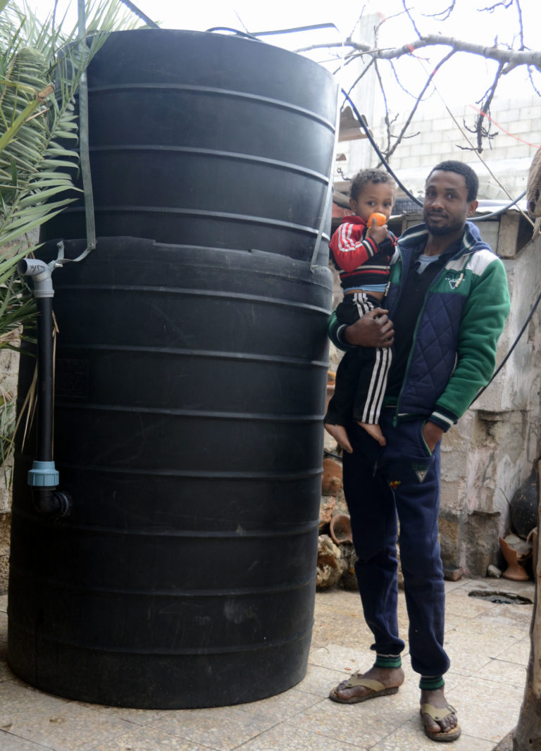 Ibrahim stands next to a new Gaza biogas digester, which turns livestock manure into fuel.