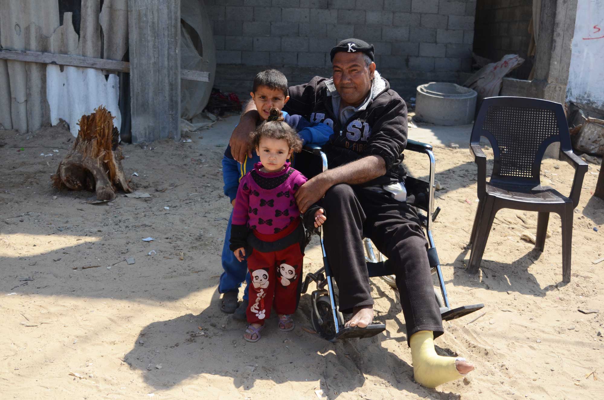 Isam and his grand kids sit outside, enjoying the clean streets.