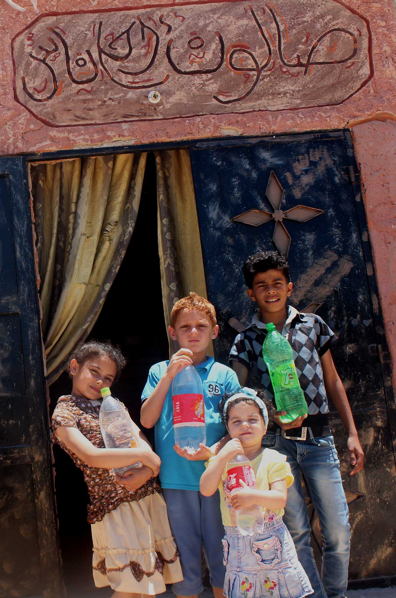 Outside “Ahla Naas,” kids from the village fill up their water bottles with clean running water.