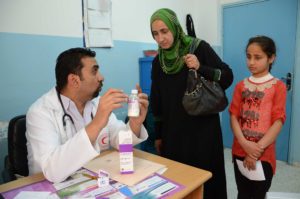 Dr. Qdeimat gives Reema and Shahd instructions for using the medication.