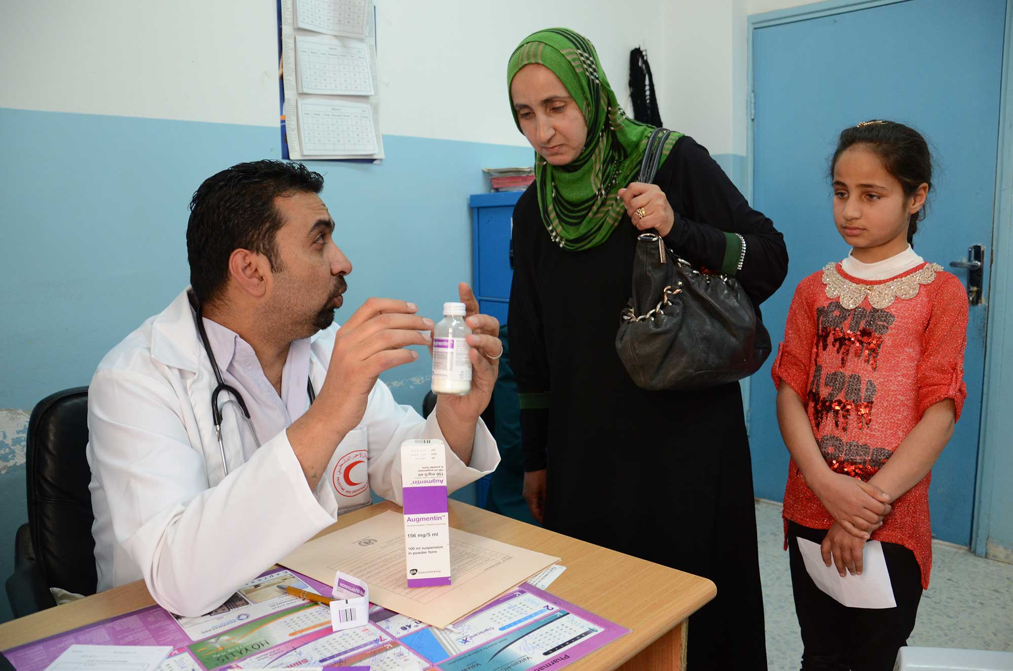 Dr. Qdeimat gives Reema and Shahd instructions for using the medication.