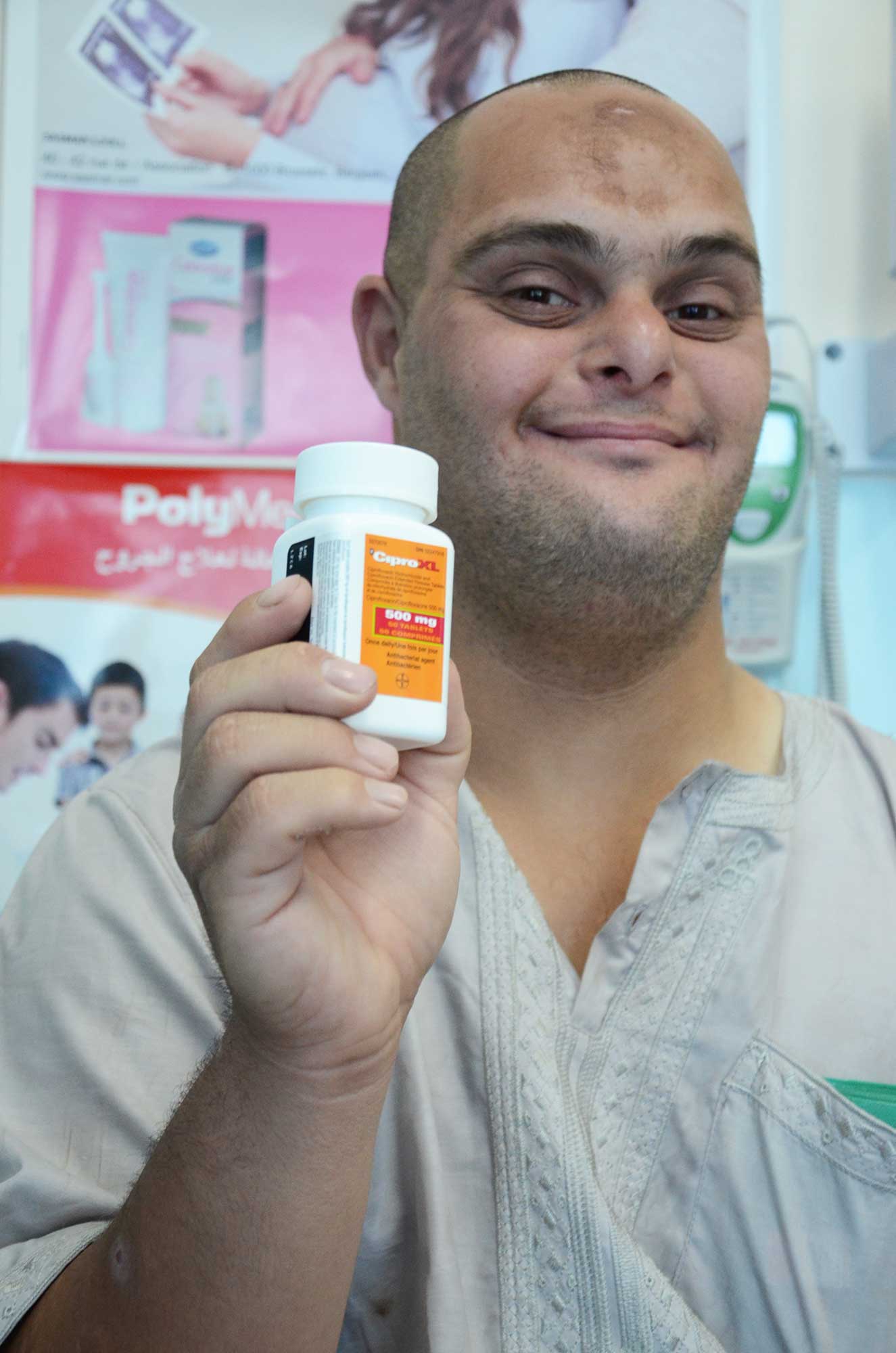 Mahmoud smiles holding the new medication.