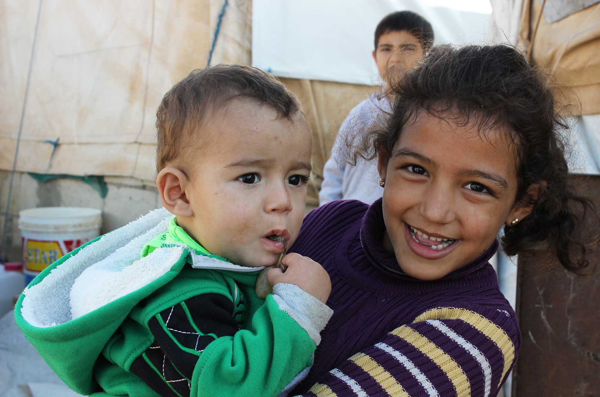 A young Syrian girl holds her baby brother in Akkar, North Lebanon. ©Niki Erickson, November 2015.