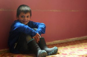 Taha, age 5, received warm winter clothing from the donation, including a jacket and boots.