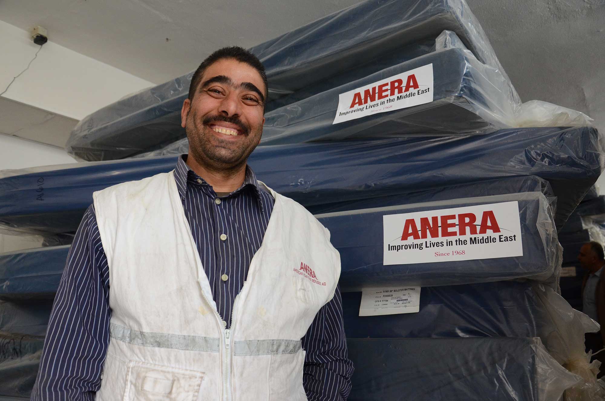 Anera in-kind warehouse assistant Mohammed Ma’tan helps deliver and unpack new mattresses at Al Ahli Hospital to replace very old, worn-out ones.