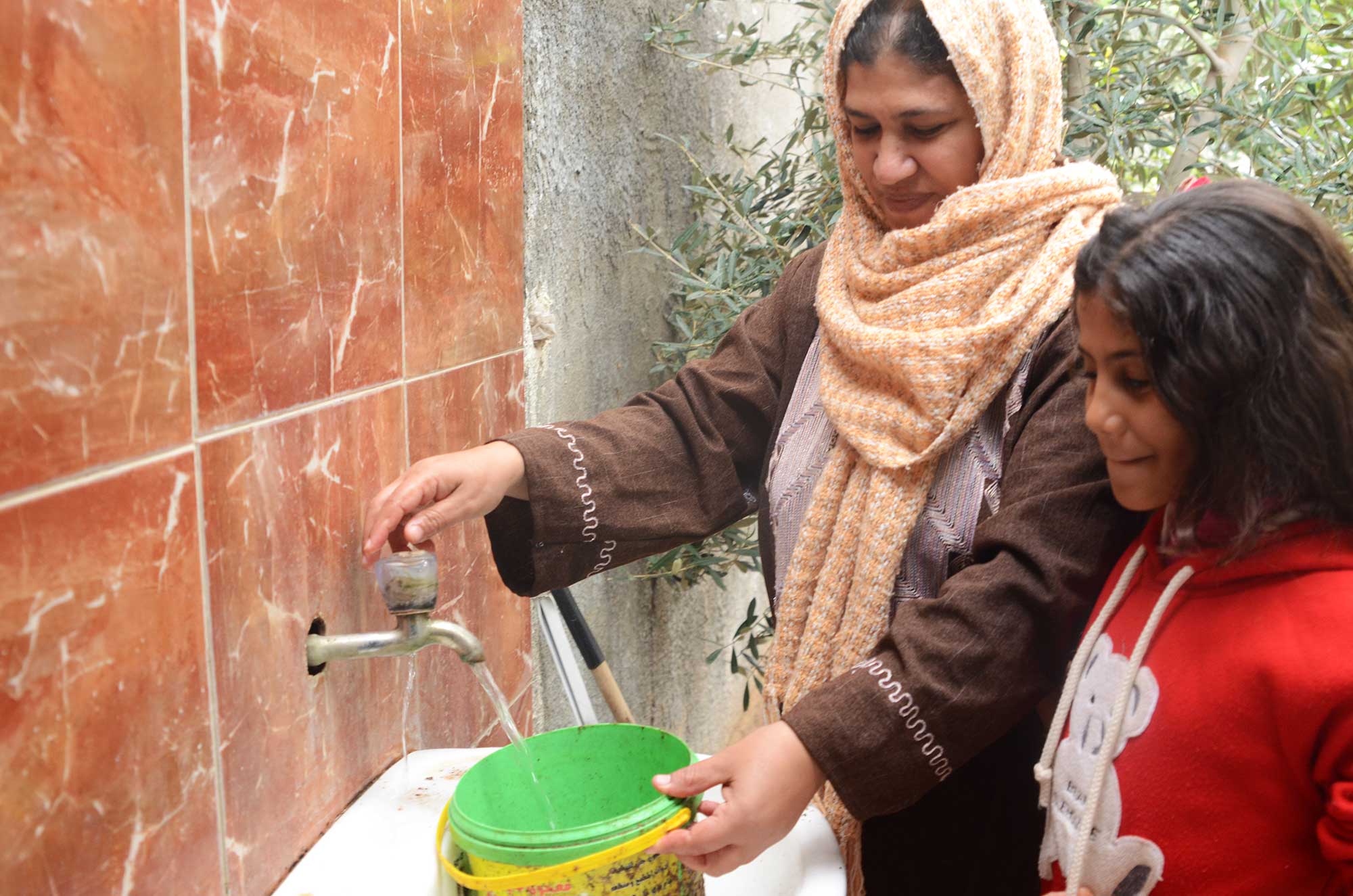 Hanan and her daughter are thrilled to have access to running water at their home. This makes tending to the livestock much easier.