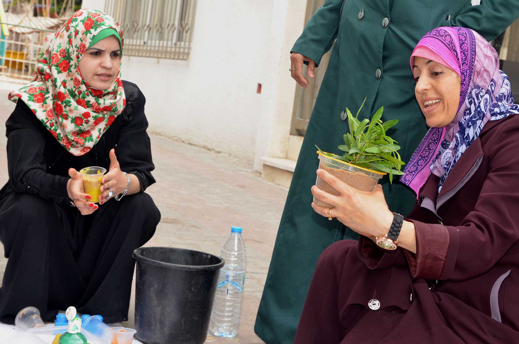 Outside, teachers use plants and paints to engage in hands-on learning practices.