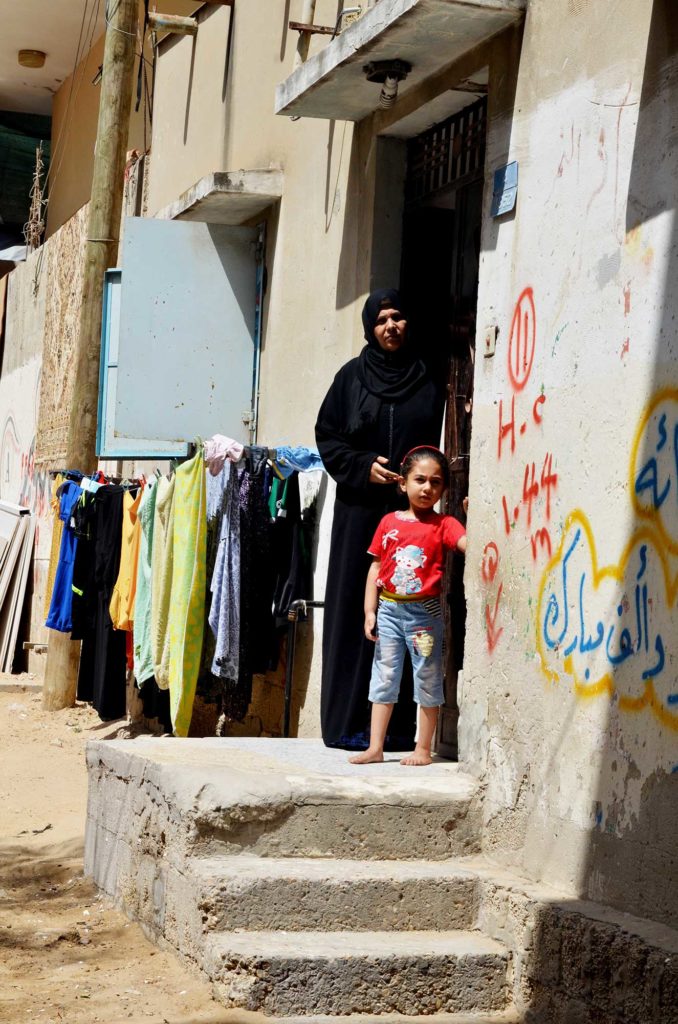 Zayna and grandmother Najah stand outside Najah’s home in the middle of Gaza City.