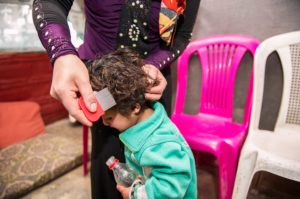 Syrian and Palestinian refugee children get lice treatment and training in Lebanon.