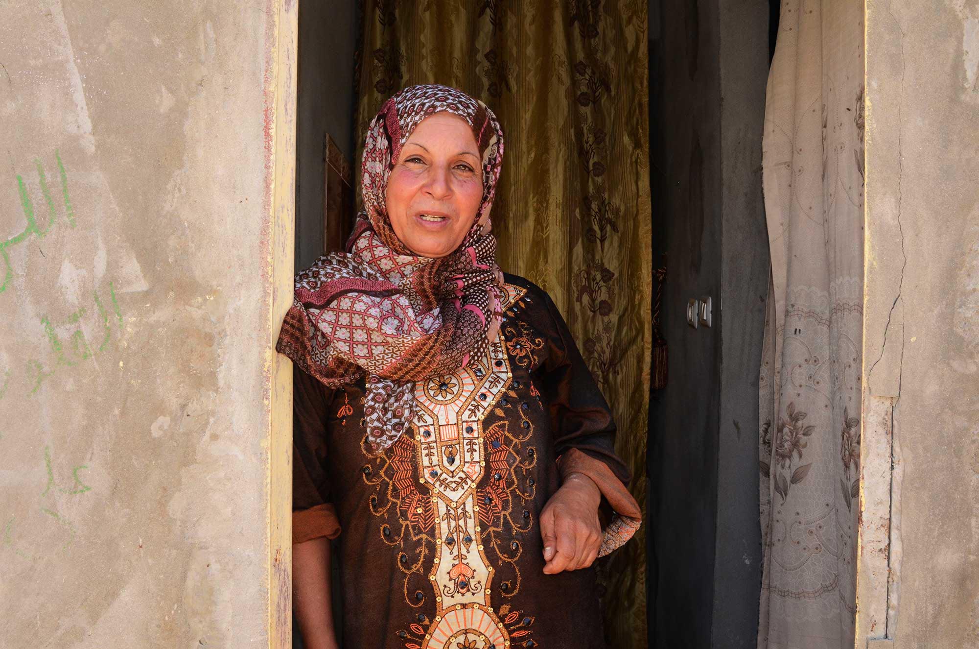 Sumaya’s neighbor stands in the doorway of her home. She’s also benefiting from the food security project.