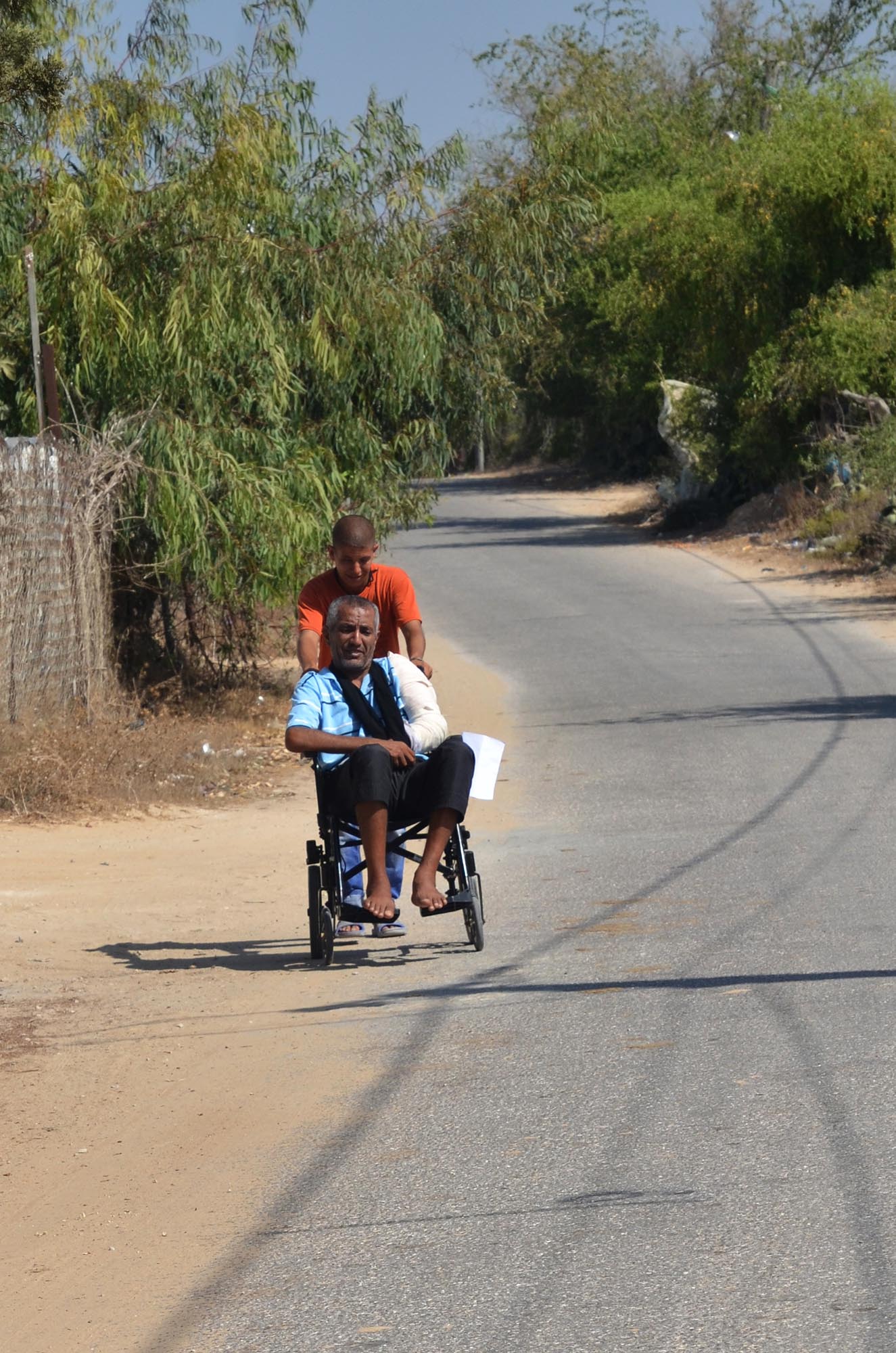Fathi's son takes him around their village on his new wheelchair.