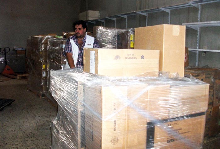 An Anera warehouse staff member moves one of many pallets of health care supplies and medicines, donated by AmeriCares.