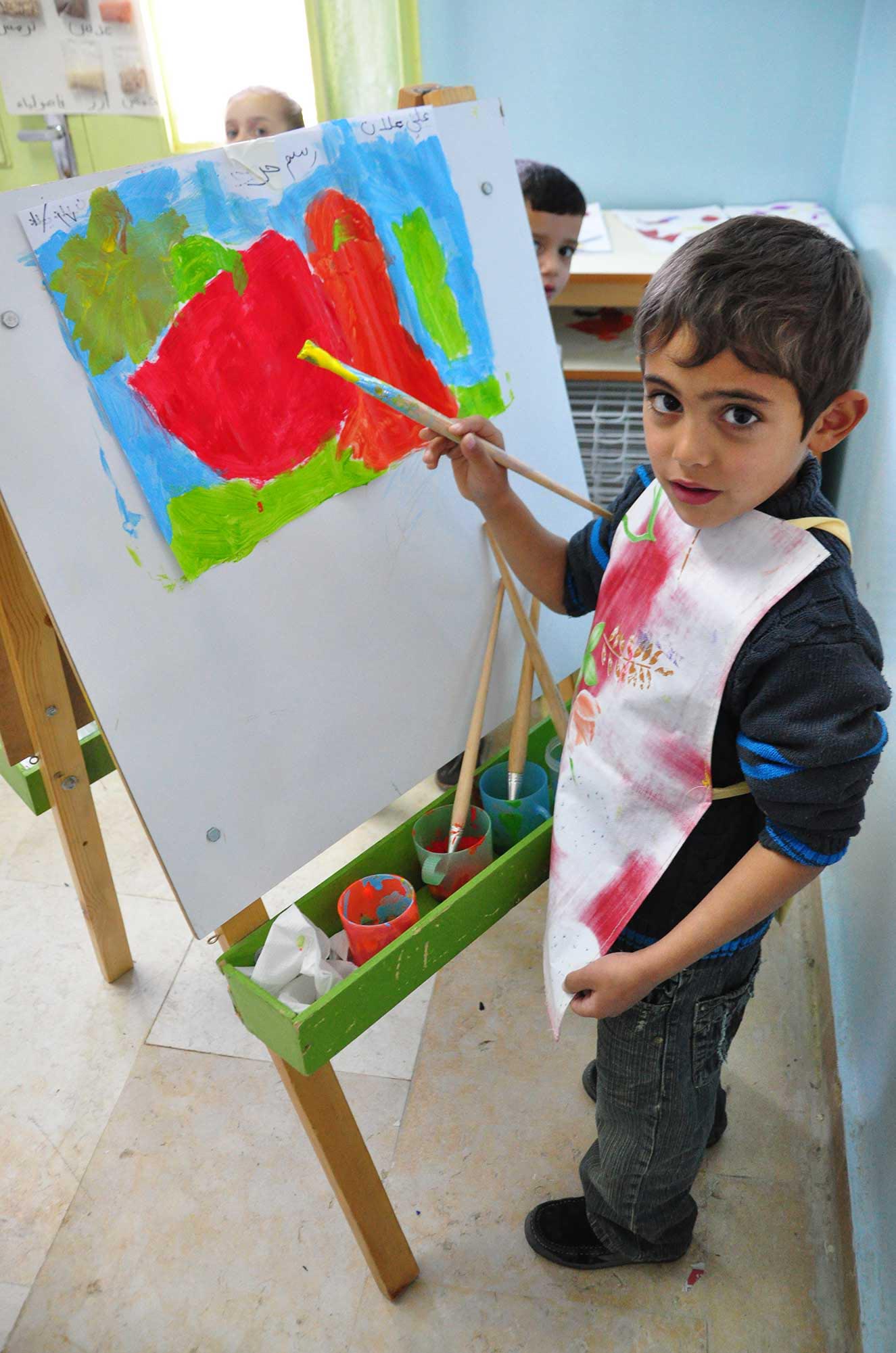 A child at the renovated Ahmad Ben-Hanbal preschool develops creative and cognitive skills through painting.
