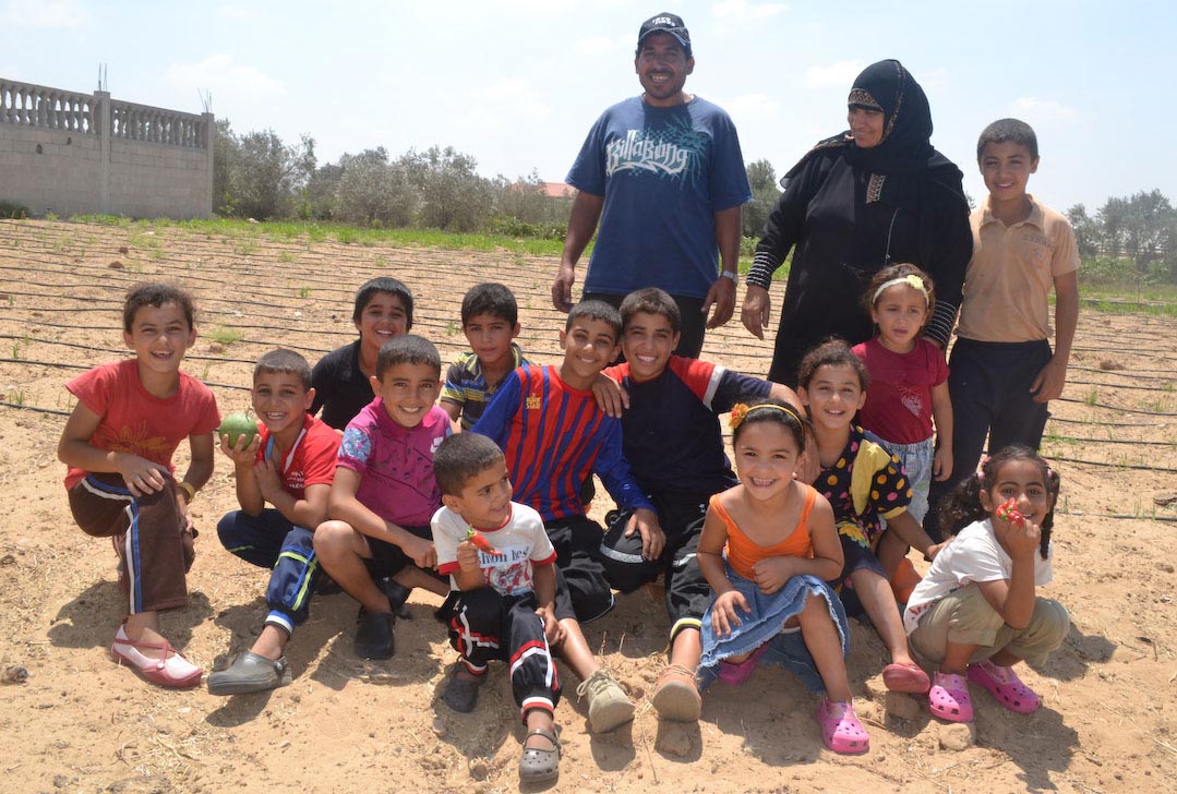 Issam and his extended family show off their new Crocs shoes from Anera.