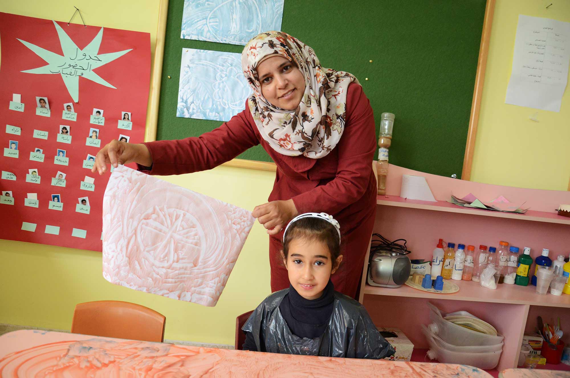 ECD-DIFFERENCE-1 Wijdan proudly holds up Dimah's finished masterpiece.