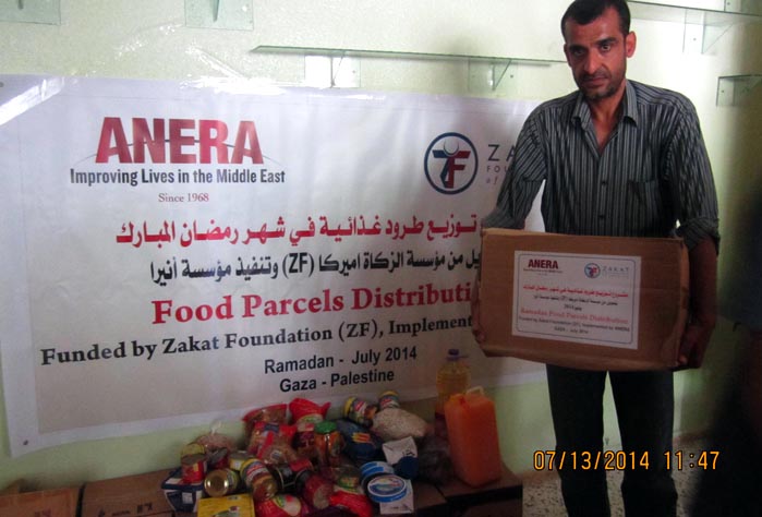 One father picks up a parcel of food from Anera filled with necessities like cooking oil, beans and pasta.