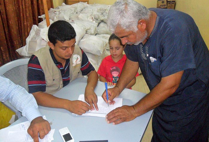 A Gaza father signs up for Anera’s emergency food parcels during Gaza war.