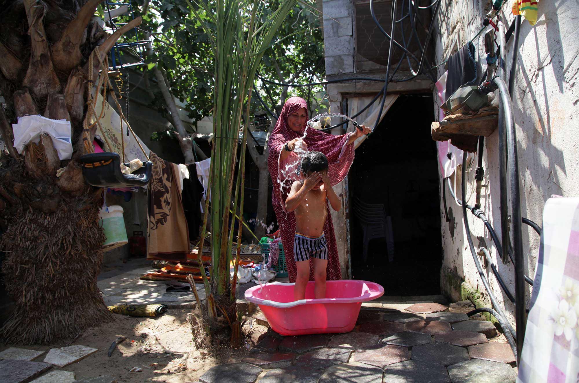 With her new water connection, Rawda is thrilled that she can give her 5-year-old son Ahmed a bath every day.