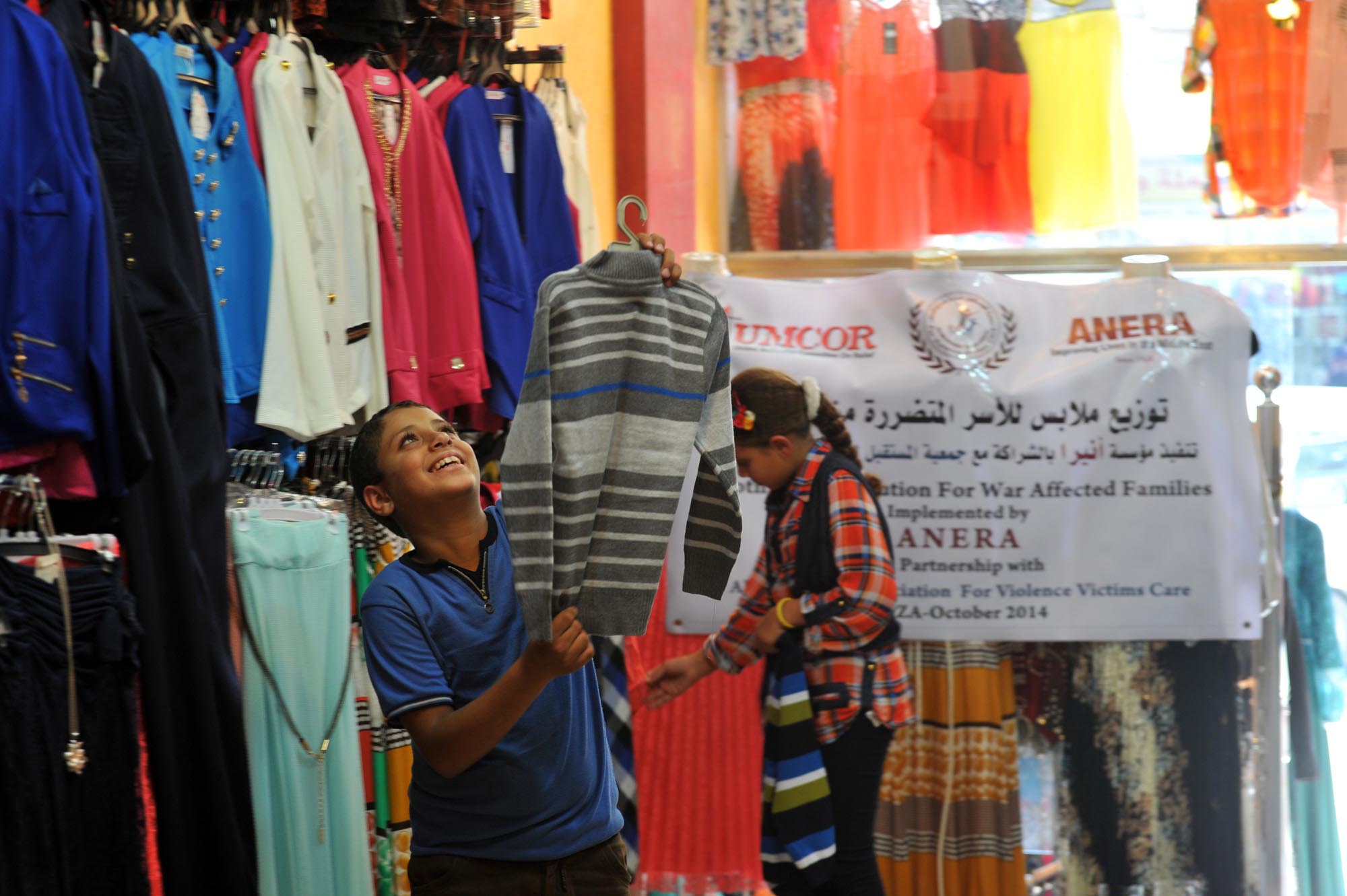 Gaza Displaced Get Clothing Vouchers A young Gaza boy, displaced by war, shops for winter clothes with Anera clothing vouchers.