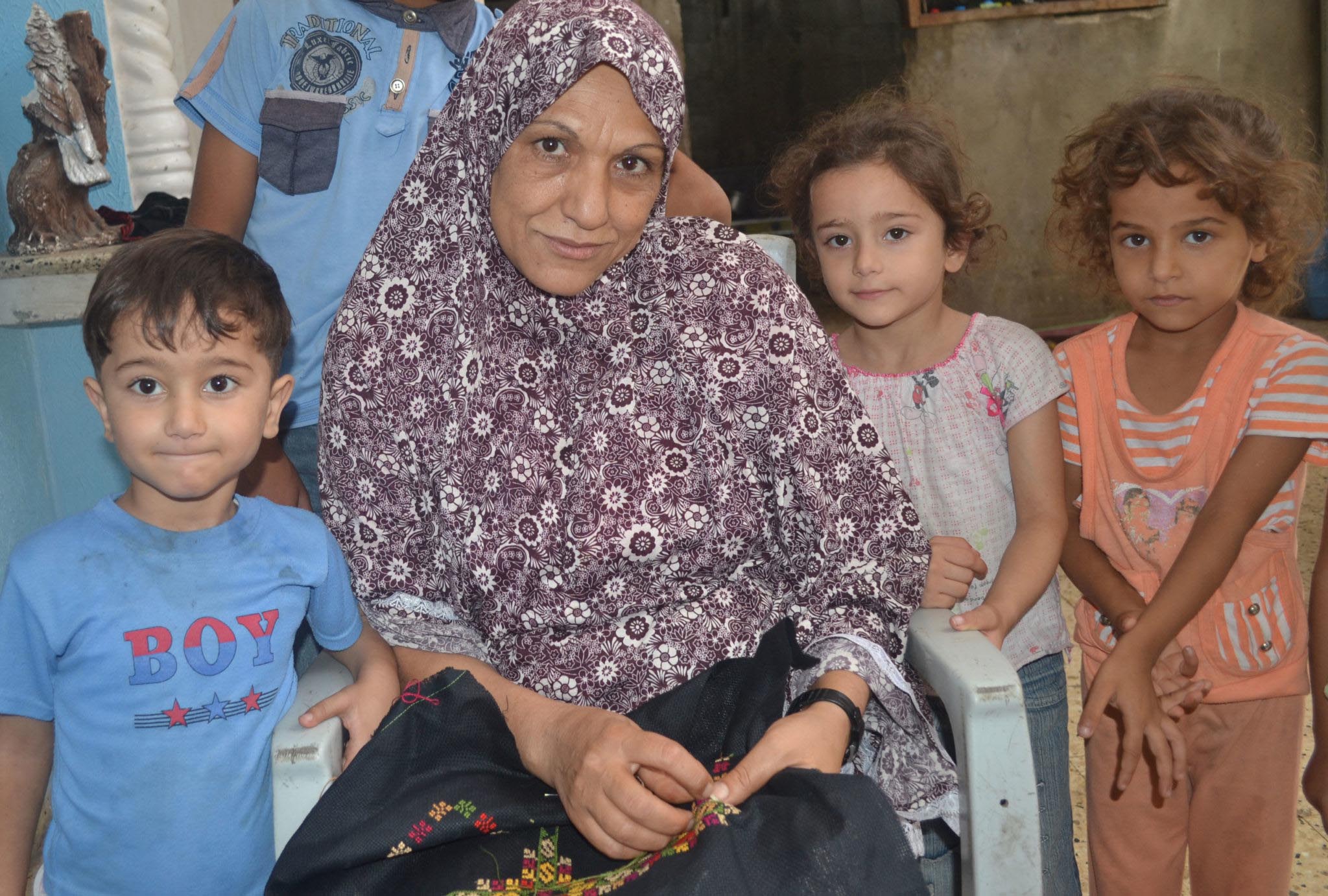 Gaza Women’s Loan Fund recipient Thareefa El Reefi shows the embroidery she sews and sells in Gaza to support her family.