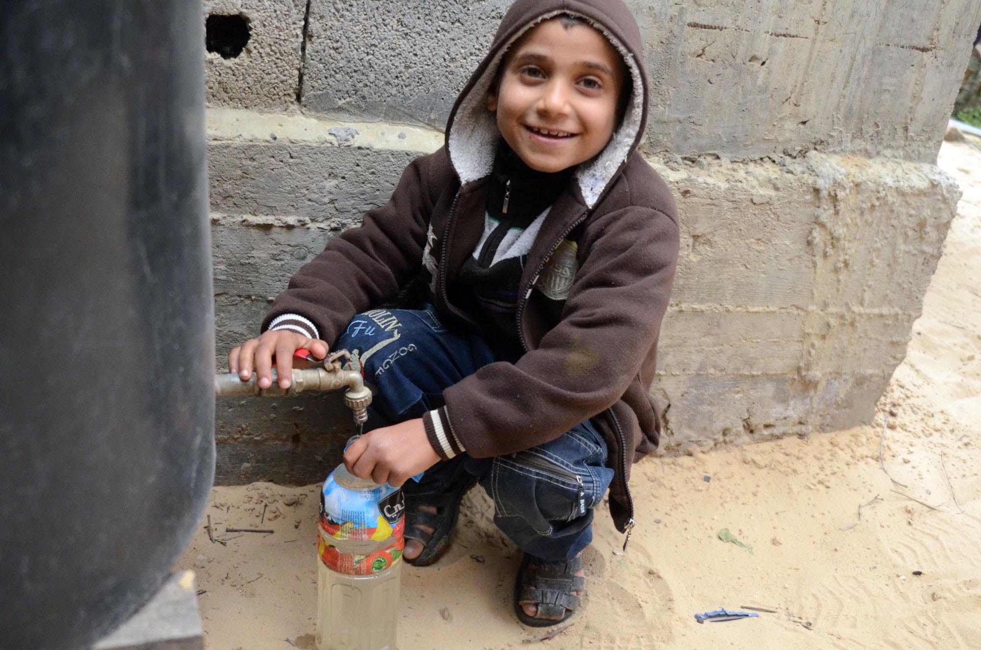 Restoring Water for Gaza Families in Beit Hanoun Now that Mohanad’s home is connected to a water network, he can fill his water bottle any time from the tank.