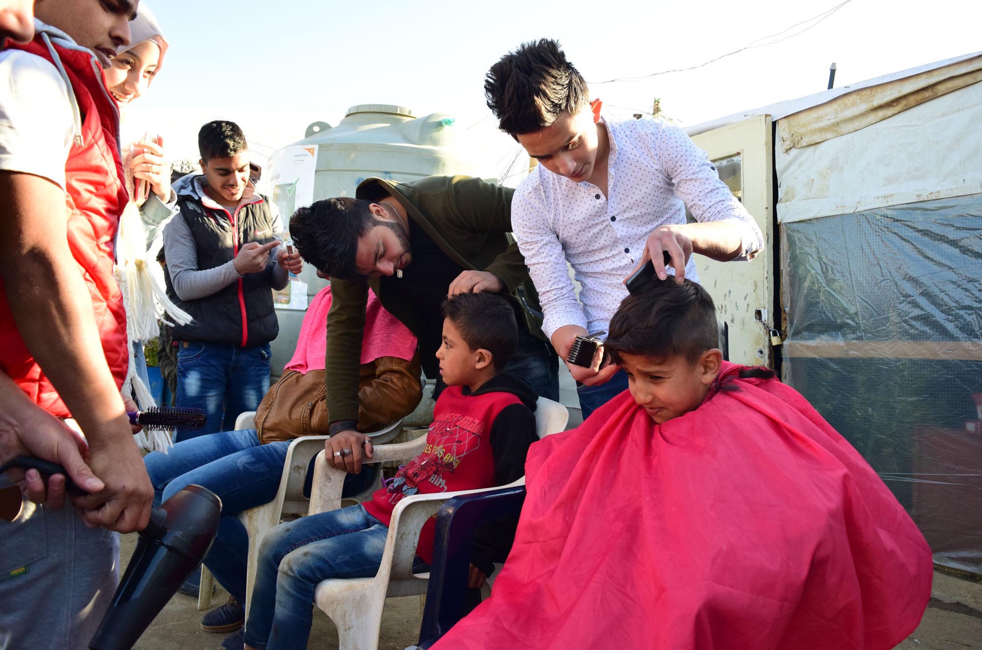 Ayham Dakar, 16, along with six other graduates from Anera's hairdressing course for men visited an informal tented settlement for Syrian refugees in Jib Jannine, West Bekaa. This open day in 2017 provided complimentary haircuts for men and boys.