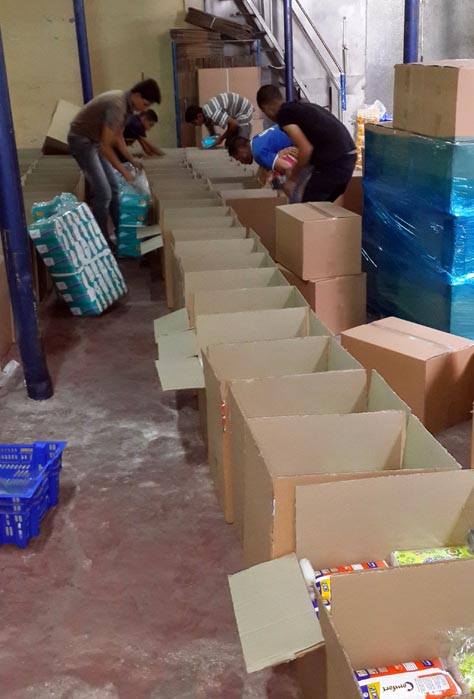 Packing up hygiene kits filled with soap, toothbrushes, towels and other personal hygiene items for displaced families in Gaza. These items were purchased and packed in the West Bank.