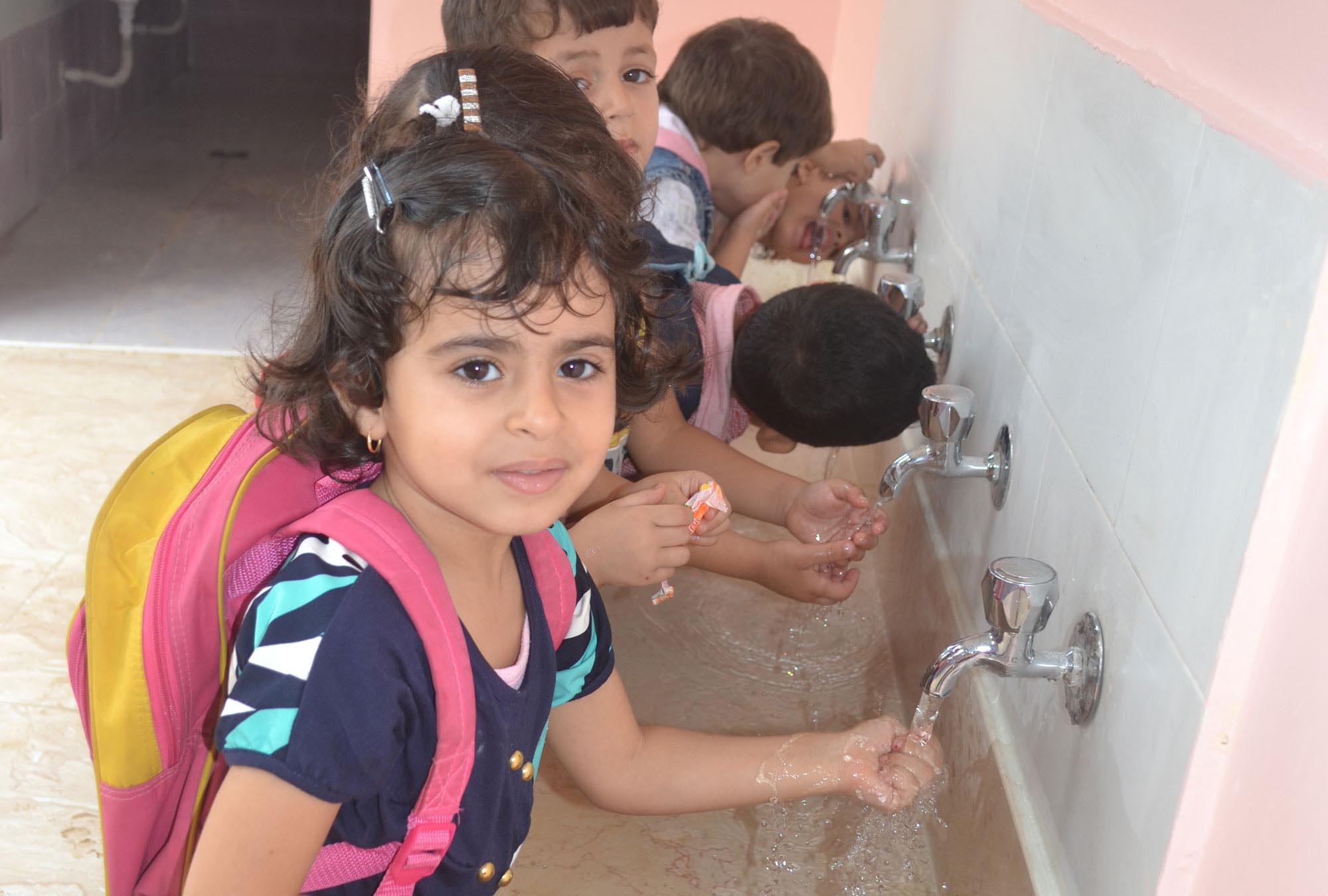 Youngsters enjoy washing hands at the new sinks Anera installed in their Gaza preschool.