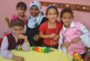 Principal Najwa at the Musaddar Preschool in Gaza shows preschoolers some new learning games.