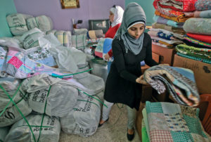 Anera volunteers prepare quilts for distribution to refugee families at the El Bass camp in Lebanon.