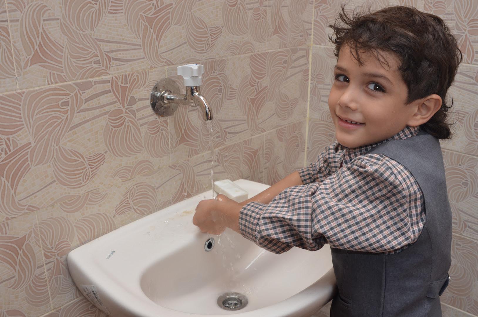 Boy at a sink at his Gaza preschool Anera renovated.